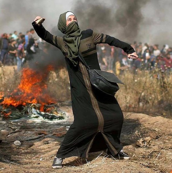 Палестинка замахнулась перед броском камня